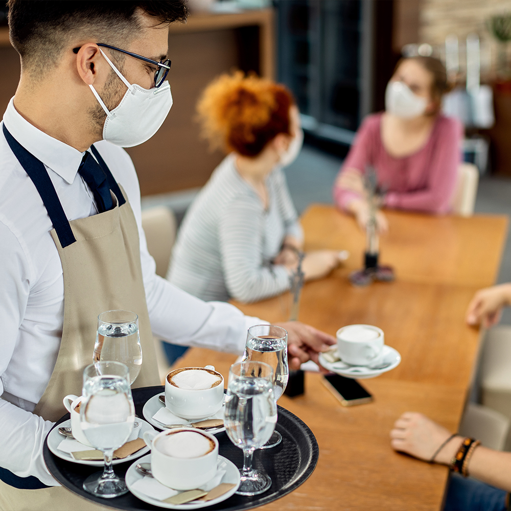 Barista serving customers in hospitality sector.