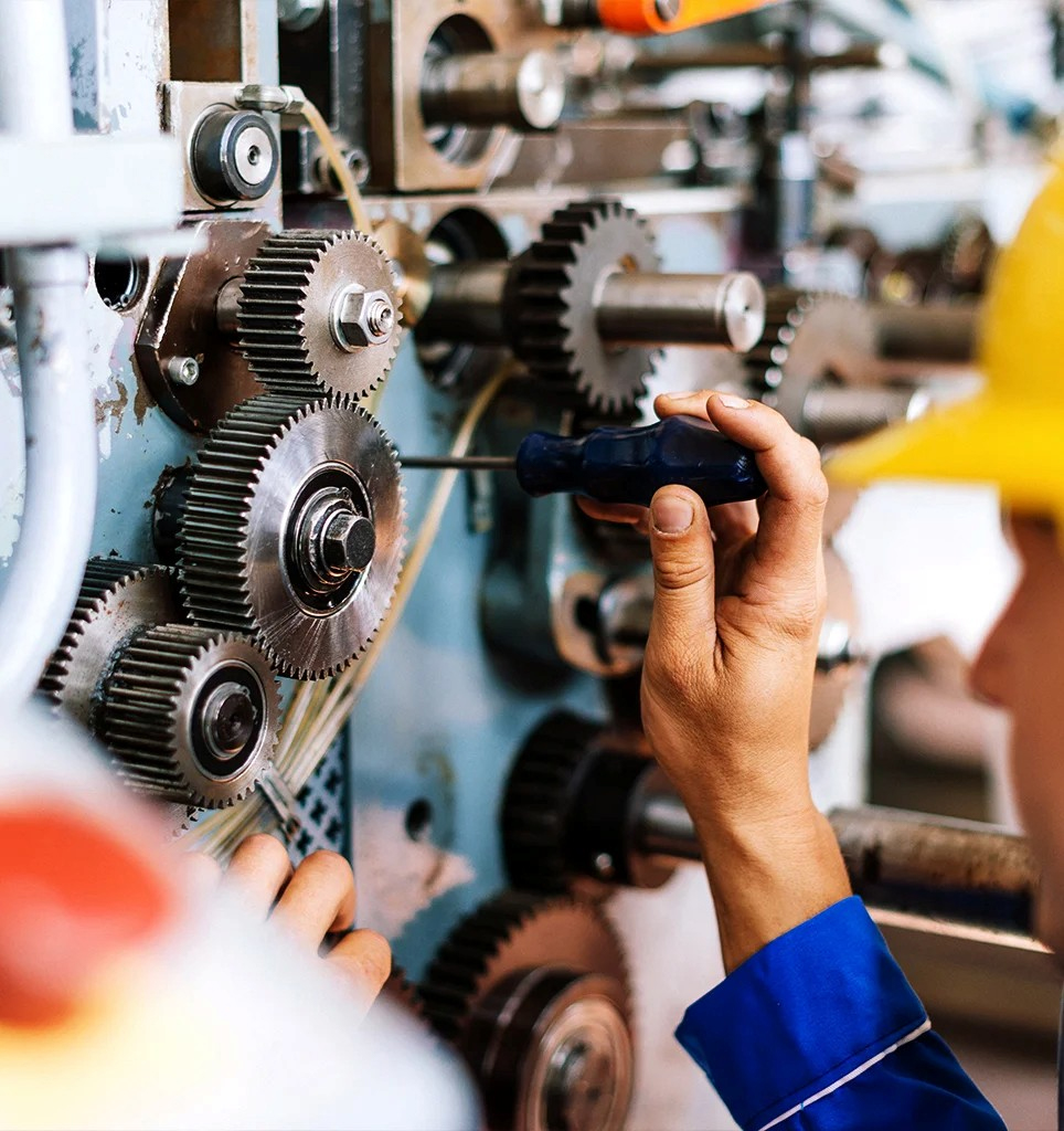 Technician repairing machine with a screwdriver